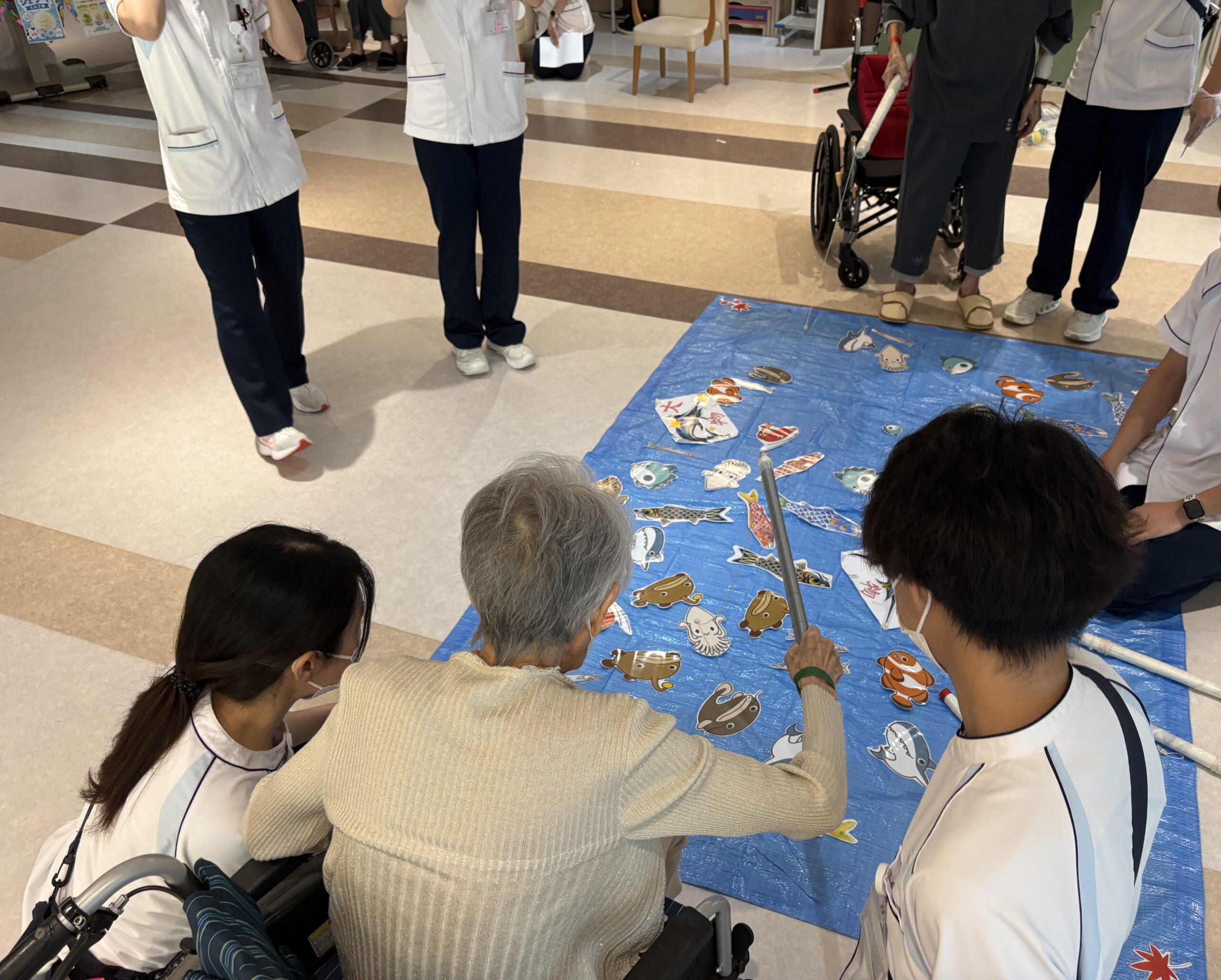 夏祭りゲームコーナーで笑顔で楽しむ患者さまの様子